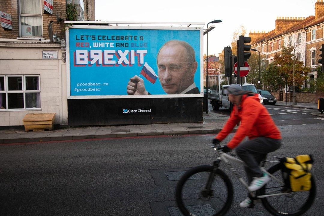 На плакатах зображена фотографія Путіна, підморгує і тримає російський прапор